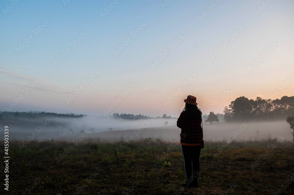 A woman standing in the morning mist
