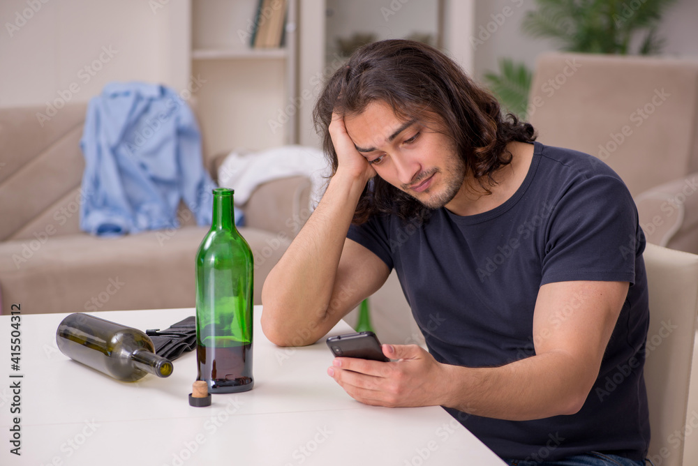 Young unemployed man drinking alcohol at home Young unemployed man drinking alcohol at home