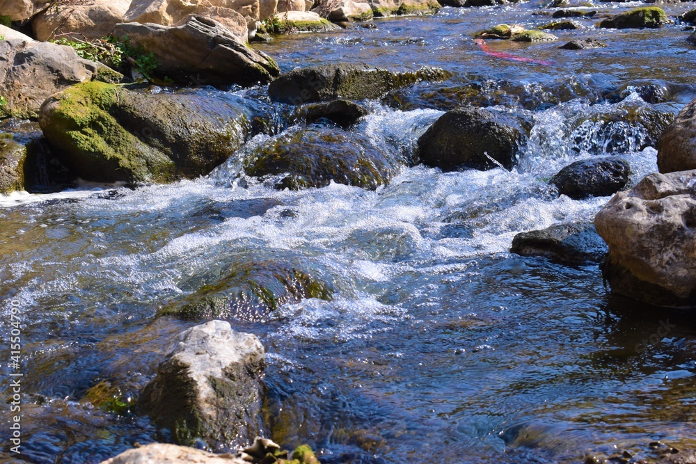 flowing water into a river against rocks flowing water into a river against rocks