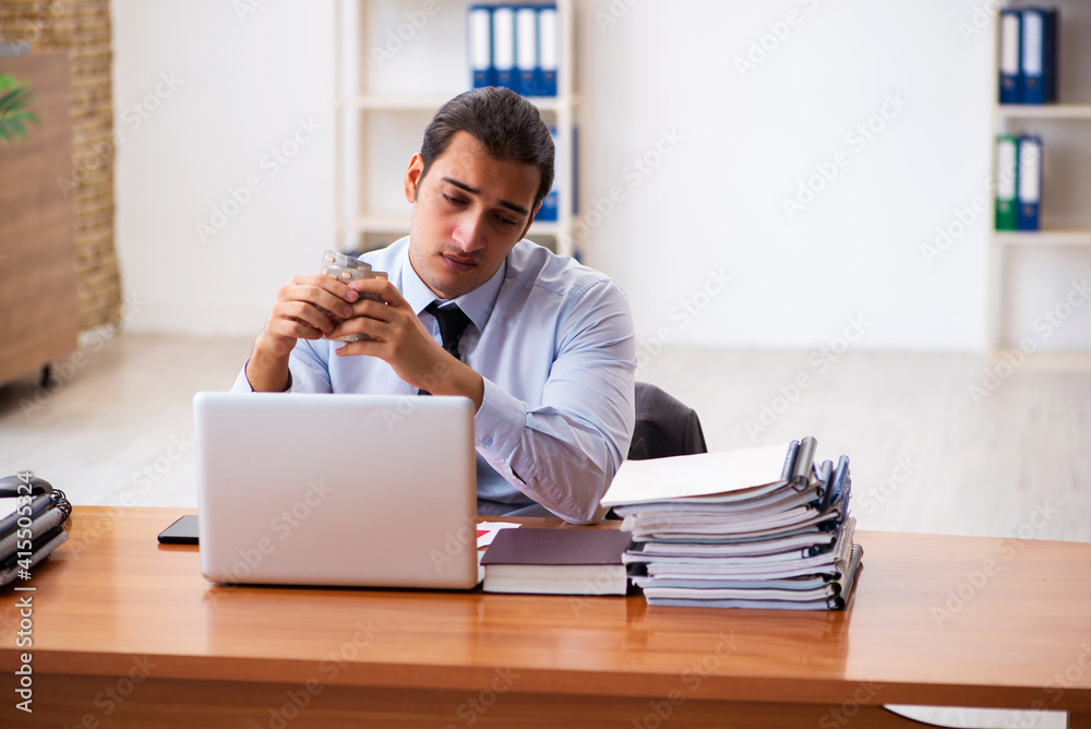 Sick male employee working in the office Sick male employee working in the office