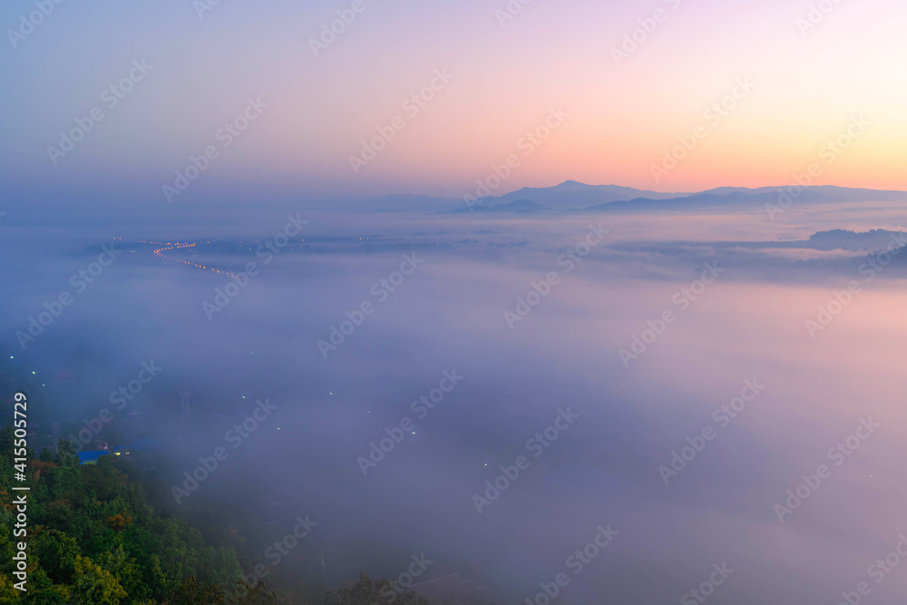 The sea of mist in the winter morning covers the village below in Li District, Lamphun Province, Thailand.