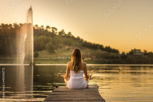 Mujer haciendo yoga en el lago