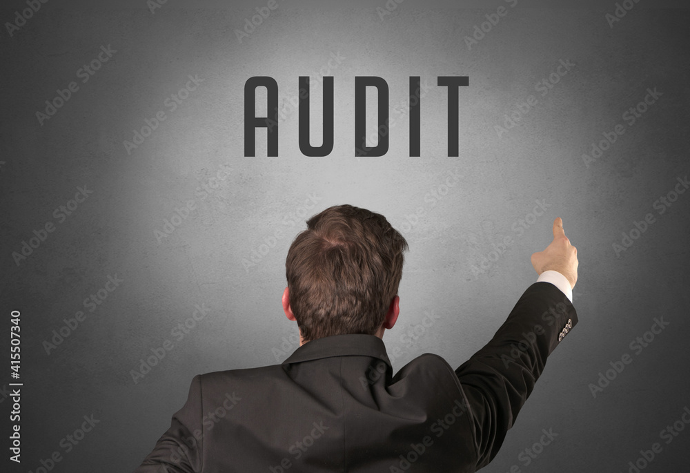 Rear view of a businessman with AUDIT inscription, powerfull business concept Rear view of a businessman with AUDIT inscription, powerfull business concept