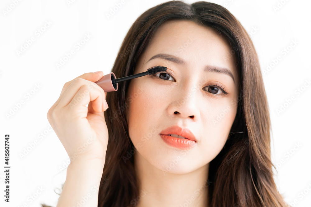 Asian woman sitting makeup in front of mirror Asian woman sitting makeup in front of mirror