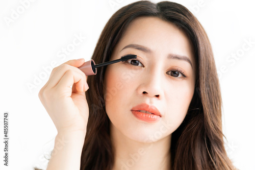 Asian woman sitting makeup in front of mirror