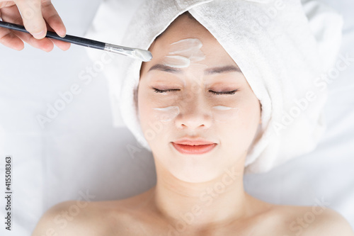 Asian woman doing beauty treatments, spa treatments and being applied cream to her face