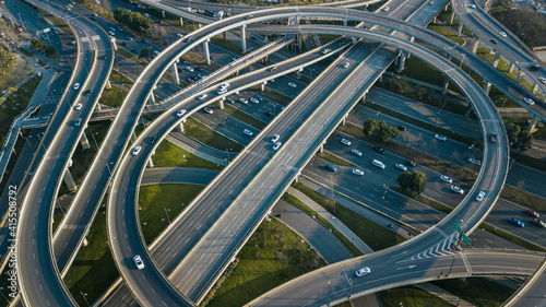Top up aerial drone view of elevated road and traffic junctions in Chinese metropolis city Chengdu during sunny day. Modern construction design of traffic ways to avoid traffic jams. Few vehicles.