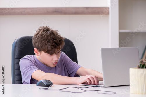 Schoolboy playing computer games at home