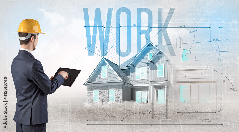 Young engineer holding blueprint with WORK inscription, house planning concept Young engineer holding blueprint with WORK inscription, house planning concept