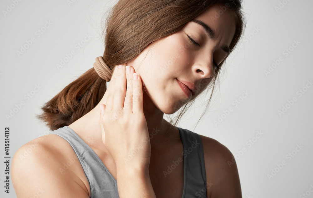 woman in gray t-shirt health problems holds hand near face pain discomfort woman in gray t-shirt health problems holds hand near face pain discomfort