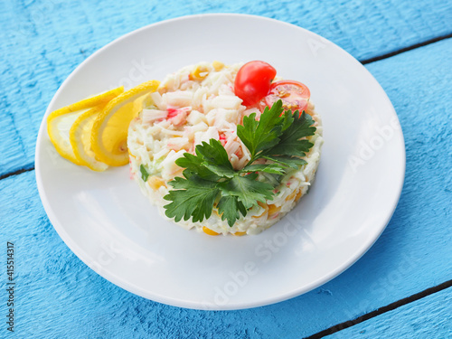 Salad with crab sticks on blue wooden background