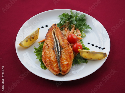 Baked salmon in foil on a red background