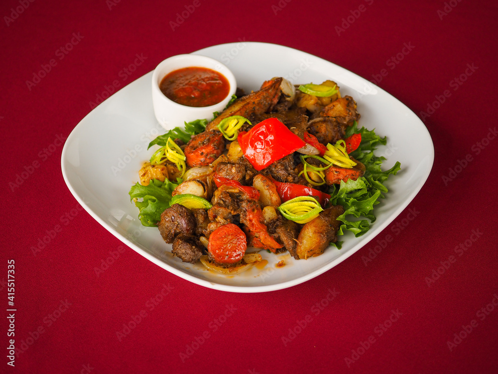 Beefsteak with tomato and herbs on a red background