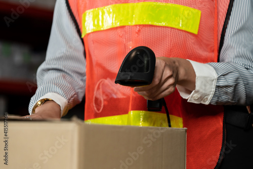 Warehouse worker using barcode scanner in storehouse . Logistics , supply chain and warehouse business concept . photo