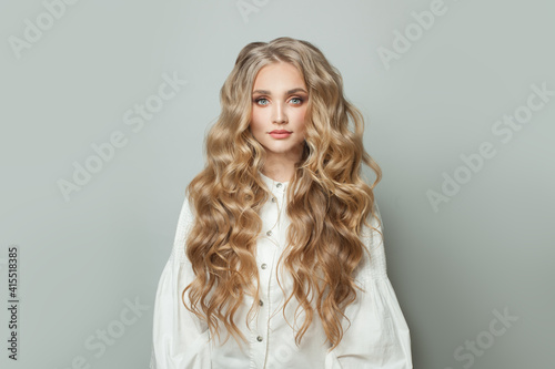 Quadro su tela Lovely woman with blonde healthy curly hair on white background
