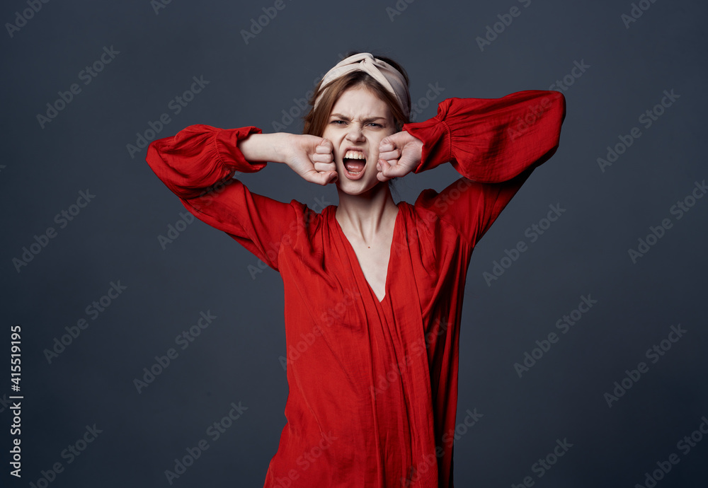 Emotional woman in red dress turban on her head ornaments gray background Emotional woman in red dress turban on her head ornaments gray background