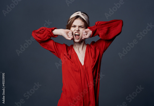 Emotional woman in red dress turban on her head ornaments gray background