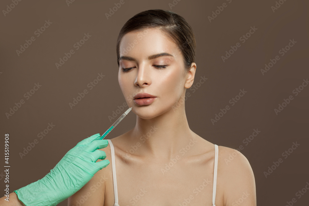 Pretty female face with syringe near lips. Lip augmentation and cosmetology concept Pretty female face with syringe near lips. Lip augmentation and cosmetology concept