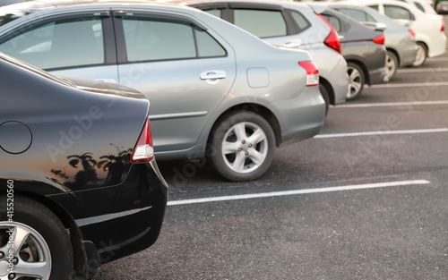 Closeup of rear or back side of black car with  other cars parking in parking area. © Amphon