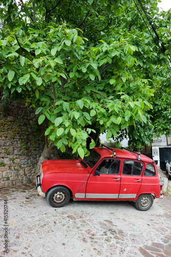 vintage red car under the tree on the street of old town in Macedonia