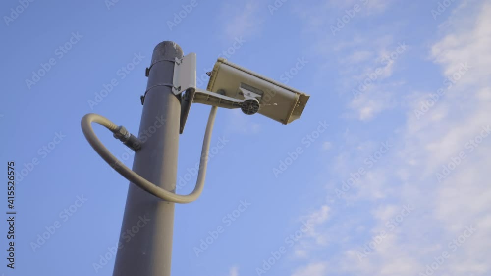 Security camera cctv video surveillance mounted on extremity steel pole and clear blue sky background, Old cctv cameras on to the top pillar on sunny day, Electronic camera monitor record,
handheld. 