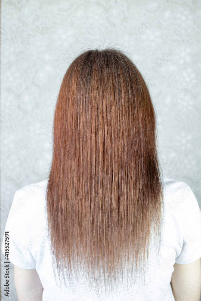 A girl with long, straight and beautiful brown hair. Hair care at home A girl with long, straight and beautiful brown hair. Hair care at home