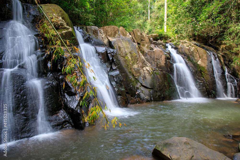 Obraz premium waterfall in the forest or motion of water at brook of water fall. with tree leaf and stone rock. at Spun or Span Nan province, Thailand, Asia.
