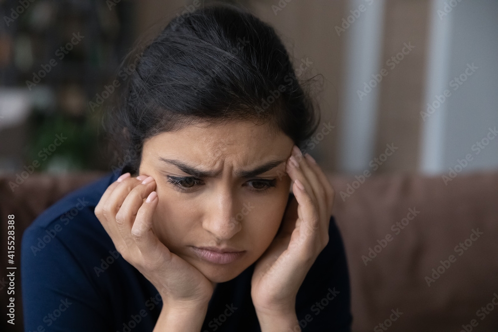 Close up of pensive sad young Indian woman look in distance think ponder of life problem solution. Unhappy thoughtful millennial mixed race female feel distressed depressed. Loner, outcast concept. Close up of pensive sad young Indian woman look in distance think ponder of life problem solution. Unhappy thoughtful millennial mixed race female feel distressed depressed. Loner, outcast concept.