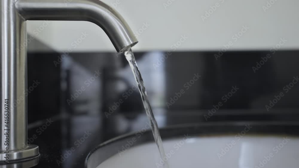 Water flowing in wash basin, Slow motion man hand turn off water vale,Close up man keeps close water tap, Turning off chrome faucet in the bathroom to save water energy and protect the environment. Water flowing in wash basin, Slow motion man hand turn off water vale,Close up man keeps close water tap, Turning off chrome faucet in the bathroom to save water energy and protect the environment.