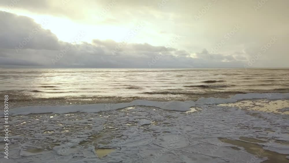 Winter landscape on sea shore with ice and snow in dark water under the sunshine Winter landscape on sea shore with ice and snow in dark water under the sunshine