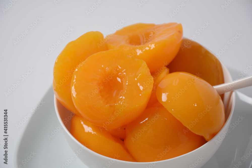 Sweet canned peaches in the ceramic bowl