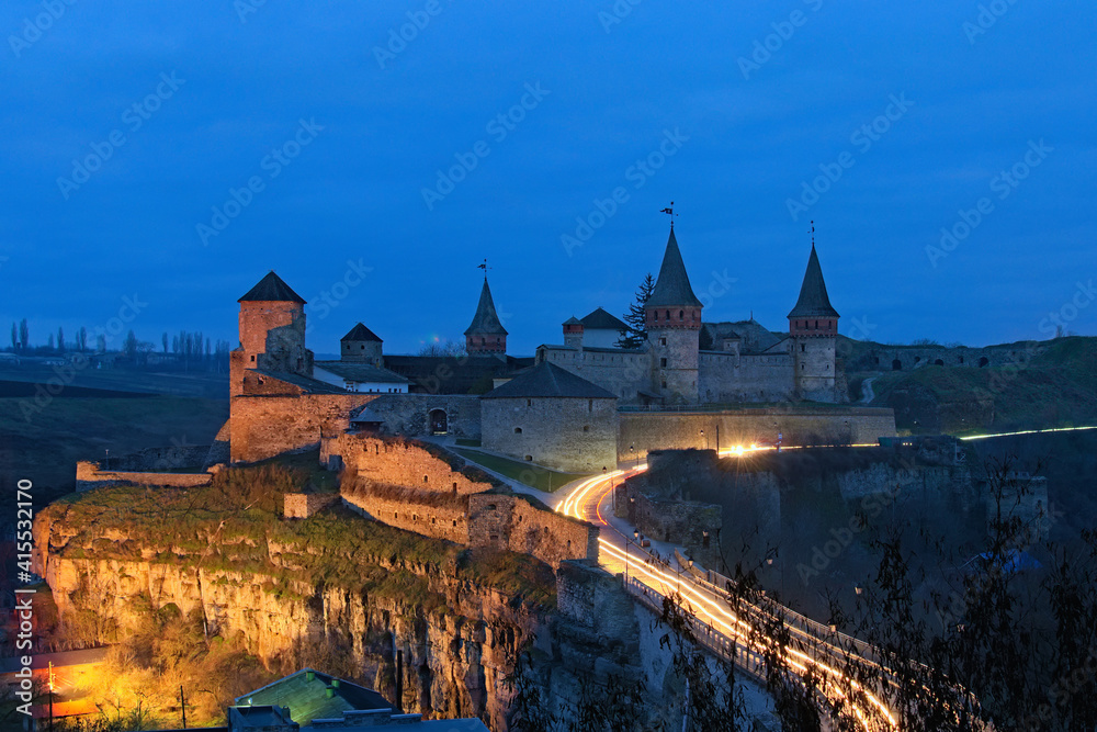 Morning landscape of ancient Kamianets-Podilskyi Castle during sunset. Colorful light trails with motion blur effect. Major tourist attraction in city. Famous touristic place and travel destination