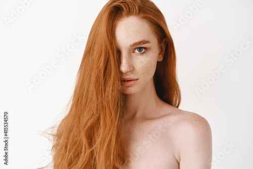 Obraz na plátně Close-up of beautiful young woman with long healthy red hair looking at camera
