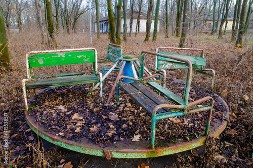 Abandoned children's camp. An old playground. Rusty carousel, rusty swing.