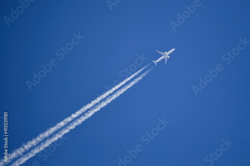 Jet plane on blue sky with vapor trail. Travel by airplane concept. 