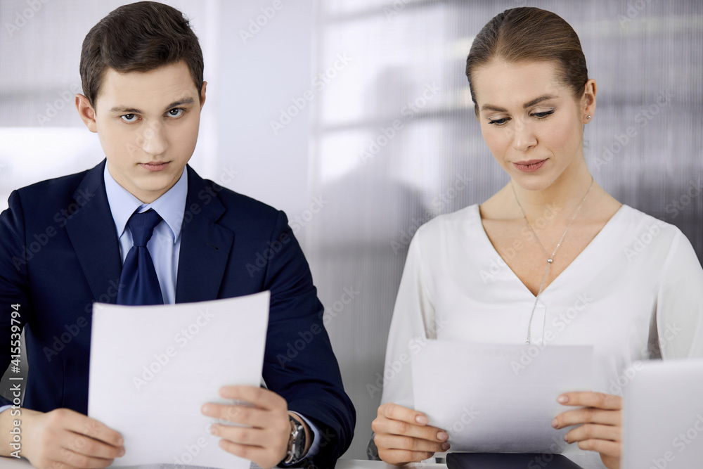 Business people discussing something while sitting in office. Focus at businesswoman while talking to her male colleague. Teamwork and meeting concept Business people discussing something while sitting in office. Focus at businesswoman while talking to her male colleague. Teamwork and meeting concept