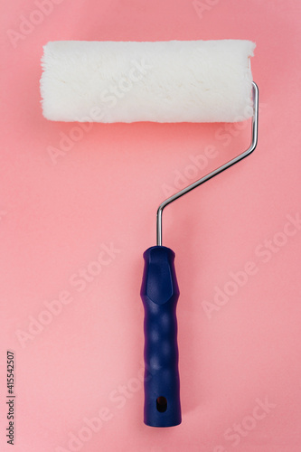 paint roller on a pink background. tools for painting and repair work.