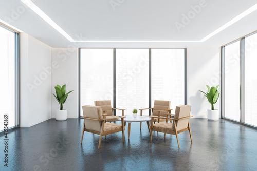 Beige armchairs in white and grey office room with plants and windows