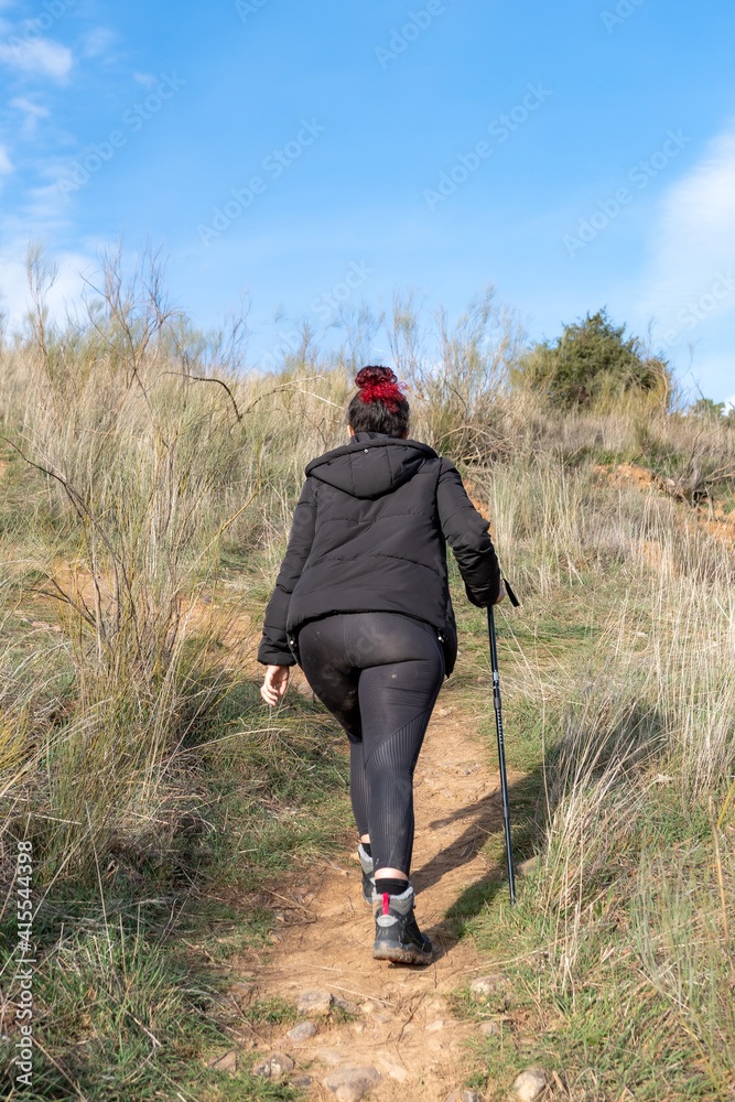 Naklejka premium Hiker climbing a hill