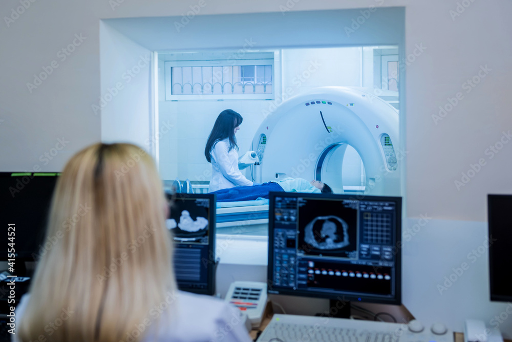 Radiologist in the control room of computed tomography at hospital ...