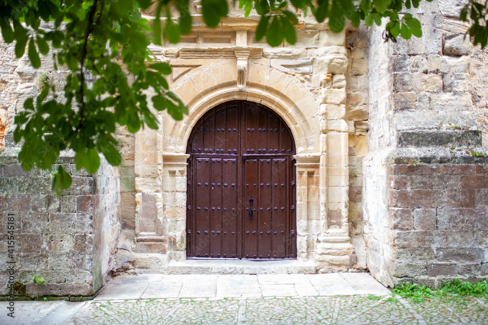 Portón de madera antiguo en pared de piedra medieval