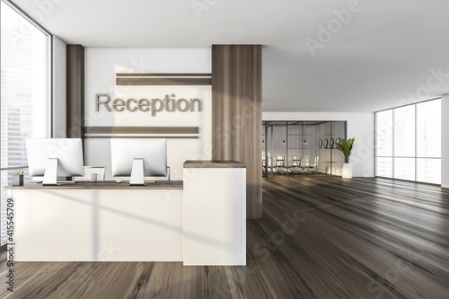 Wooden reception room with desk and computers near window