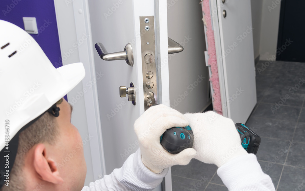 master in gloves and helmet, close-up, drilling out the old lock after the mechanisms break down for further repair and replacement master in gloves and helmet, close-up, drilling out the old lock after the mechanisms break down for further repair and replacement