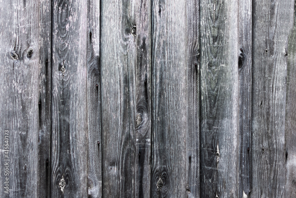 A fence made of old boards. The boards are gray.