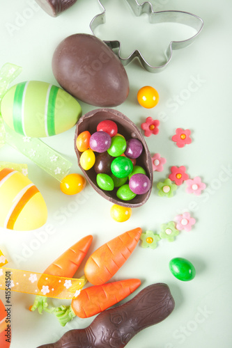 Easter set with colorful eggs, carrots, candy, cupcake. Top view.