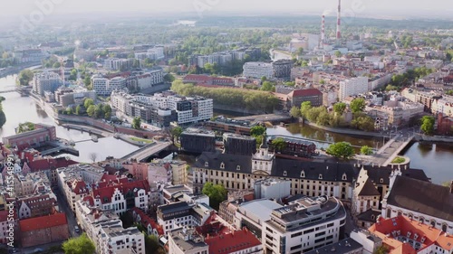 Drone view of beautiful buildings by the river. Vibrant city with nature elements. Aerial shot of Wrocław city centre.