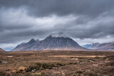 Stunning majestic landscape image of Buachaille Etive Mor and River Etive in Scottish Highlands on a Winter morning with moody sky and lighting