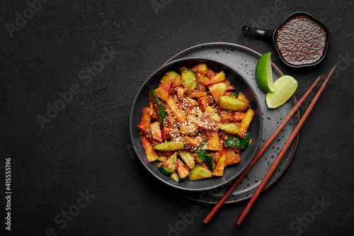Penang Rojak in black bowl on dark slate table top. Malaysian or indonesian cuisine fruits and vegetables salad dish. Asian Food. Top view. Copy space