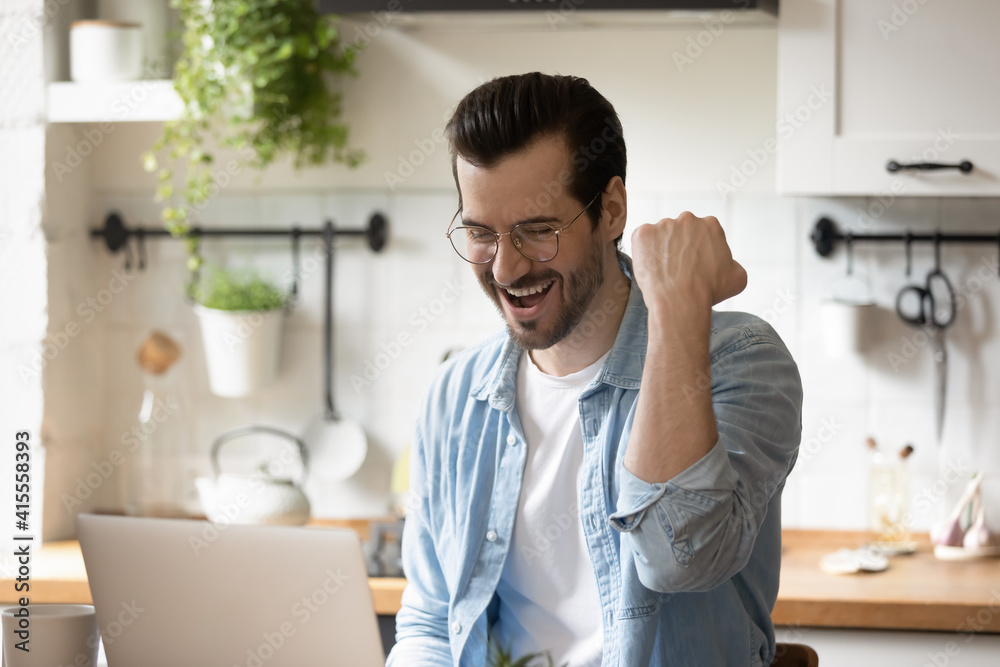 Overjoyed young Caucasian man look at computer screen feel euphoric read good news in email letter. Happy excited millennial male celebrate online lottery win on laptop. Luck, success concept.