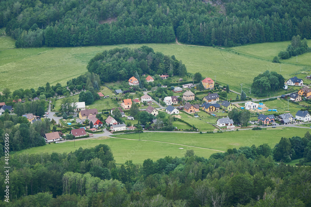 Aerial view on small Czech village with green fields and forest around